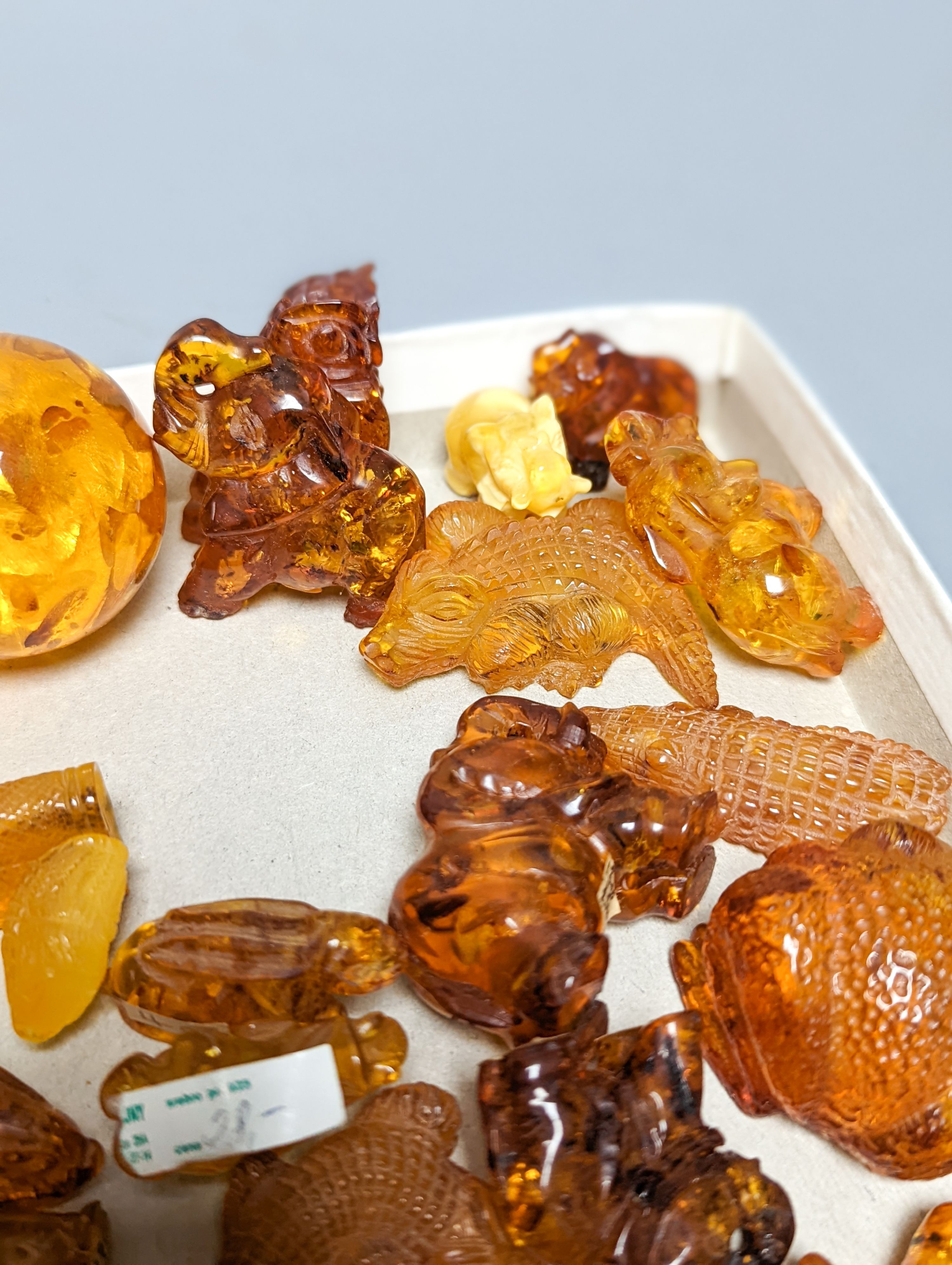 A mixed collection small carved amber wares including dice, eggs and cigarette holders, etc.